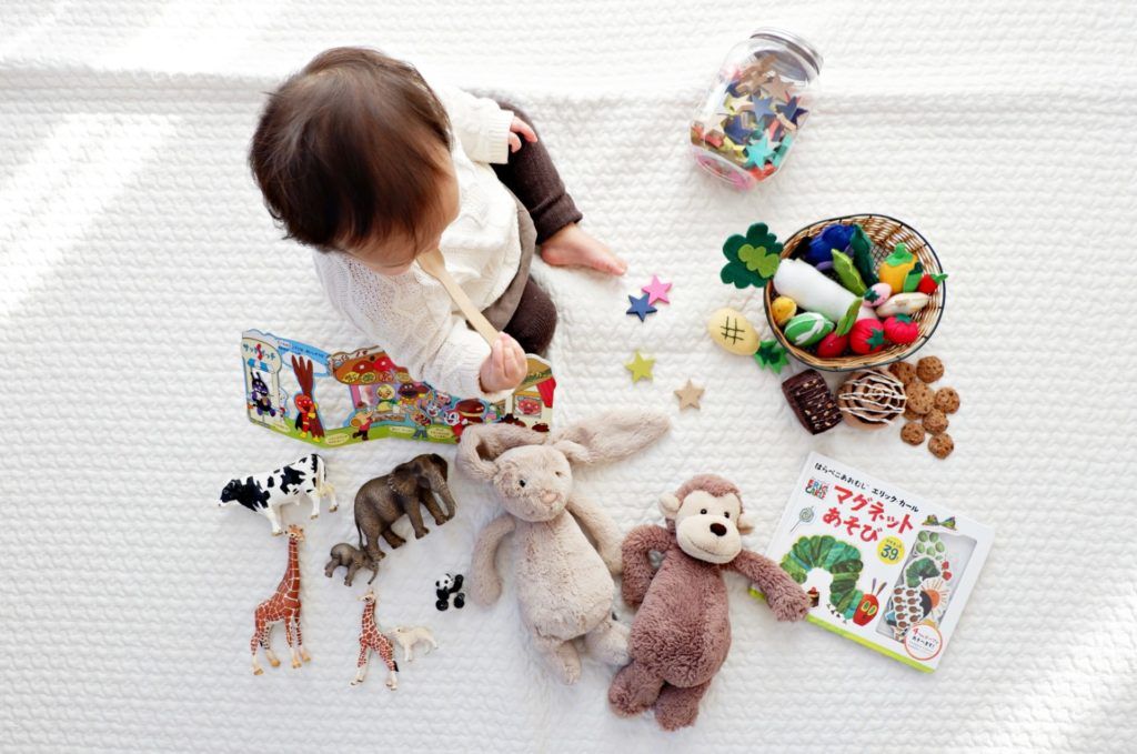 child sitting on floor playing with toys